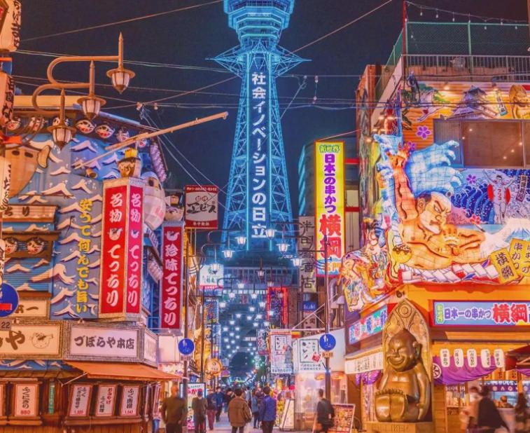 a busy city street with a tower in the background at 通天閣徒歩1分3ベッド in Osaka