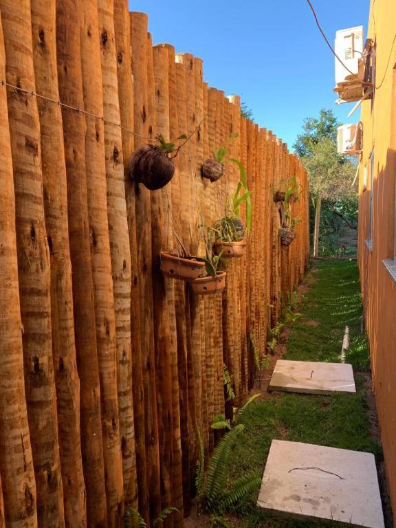 a wooden fence with potted plants on it at Casa às margens do Rio Caraíva, área verde in Caraíva