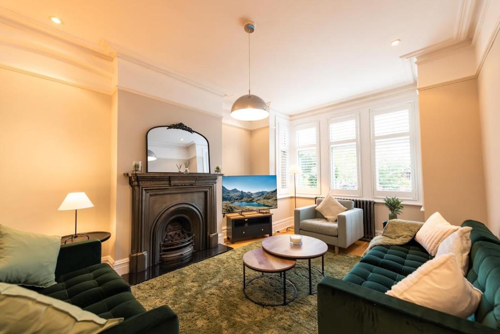 ein Wohnzimmer mit Couch und Kamin in der Unterkunft The Shakespeare -5Bed 3Bath in Ealing