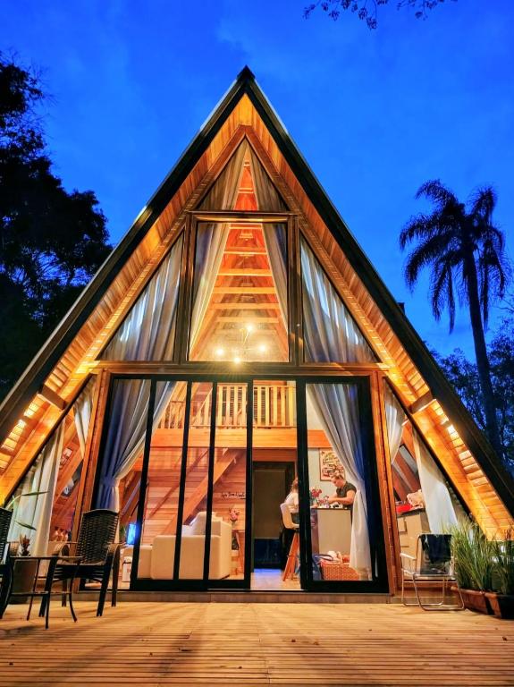 a house with large glass windows and a tree at Cabanas Laurita BG in Bento Gonçalves