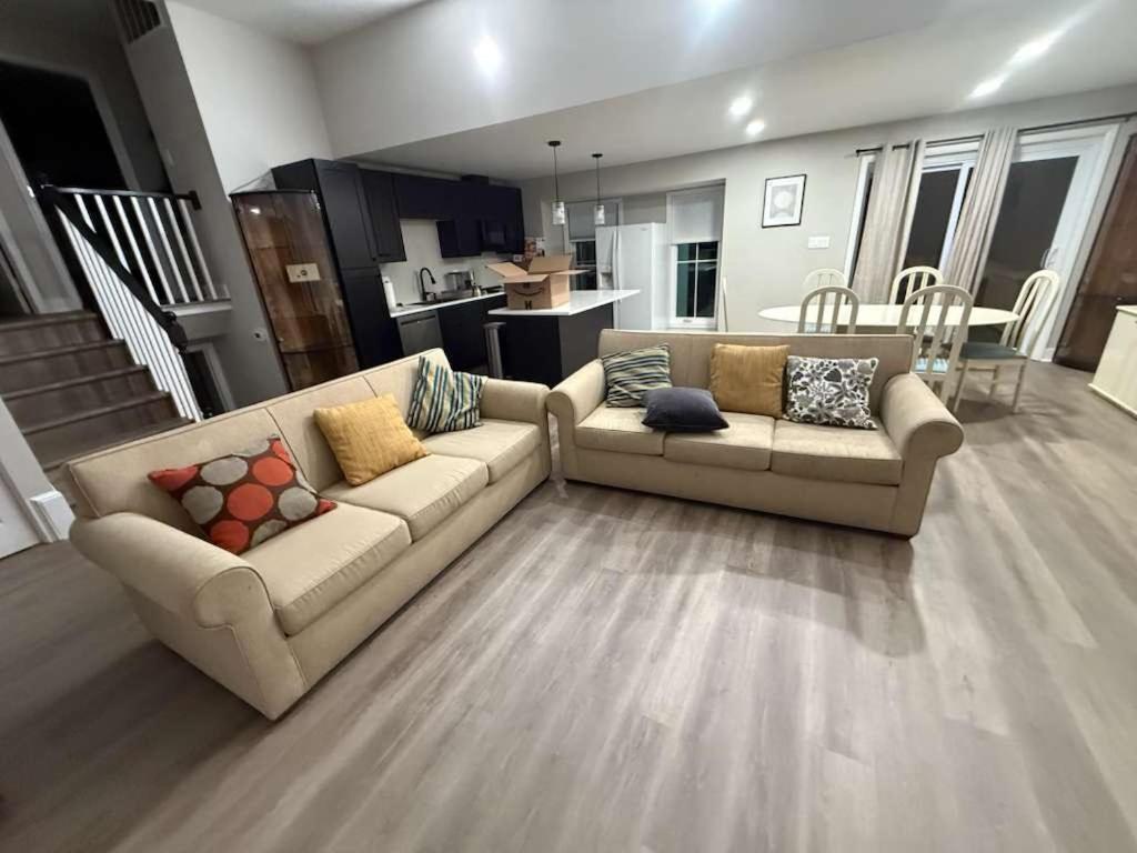 een woonkamer met twee banken en een keuken bij Spacious 5 bedroom single family home sleeps 12 with driveway near DC in Bethesda