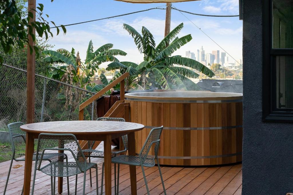 a table and chairs on a deck with a hot tub at Hillside House with DTLA Views in Los Angeles