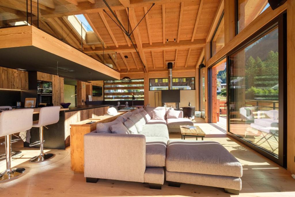 a living room with a large couch and chairs at Chalet Aikoa in Chamonix-Mont-Blanc