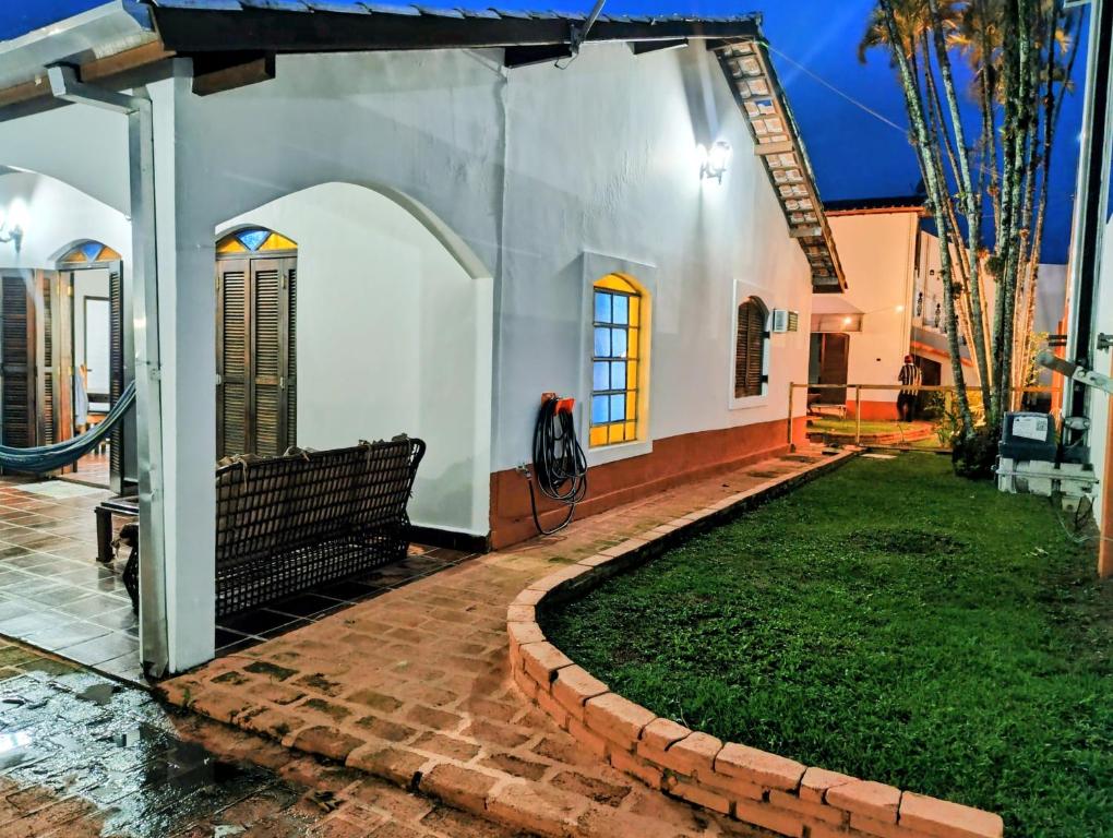 ein Haus mit einem gemauerten Gehweg neben einem Hof in der Unterkunft Casa Cantinho no Litoral in São Sebastião