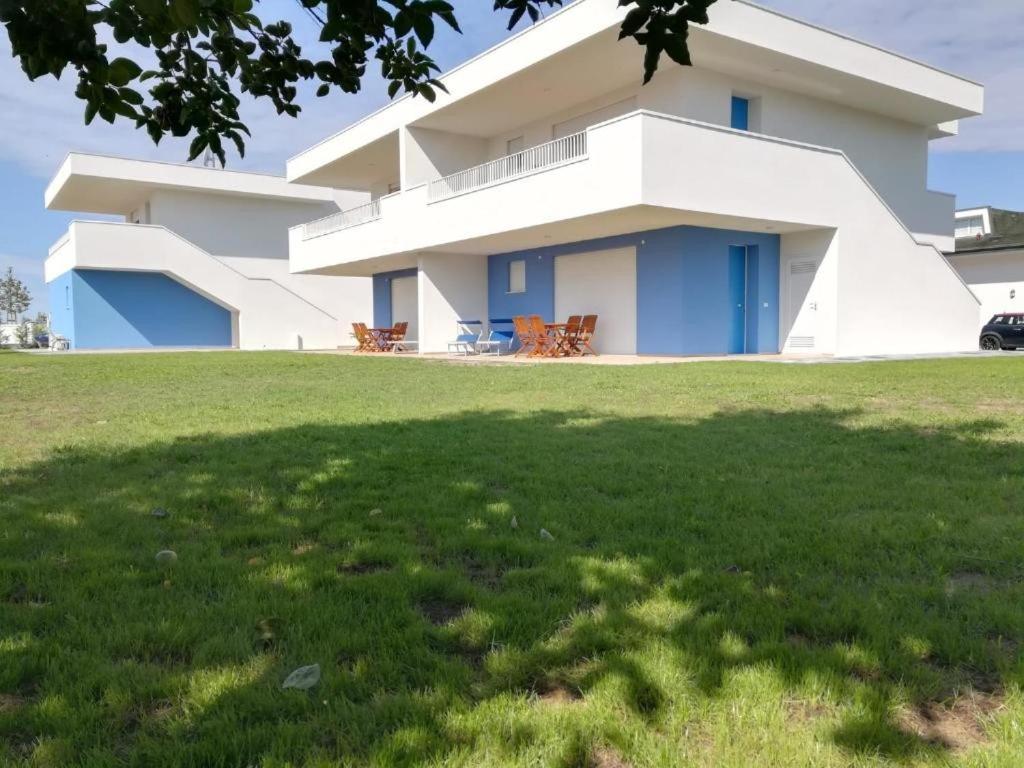 a house with a green lawn in front of it at Residence Blumar Jesolo Golf Club in Lido di Jesolo