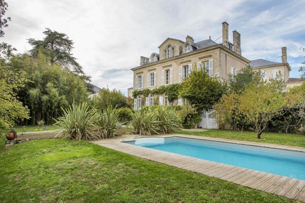an estate with a swimming pool in front of a house at Suite Oiseau du Paradis in Fontenay-le-Comte