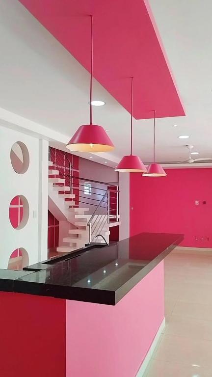 une cuisine aux murs rouges et blancs et aux suspensions lumineuses dans l'établissement Casa Sobrado Confortavel, Descanso Garantido, à Cuiabá