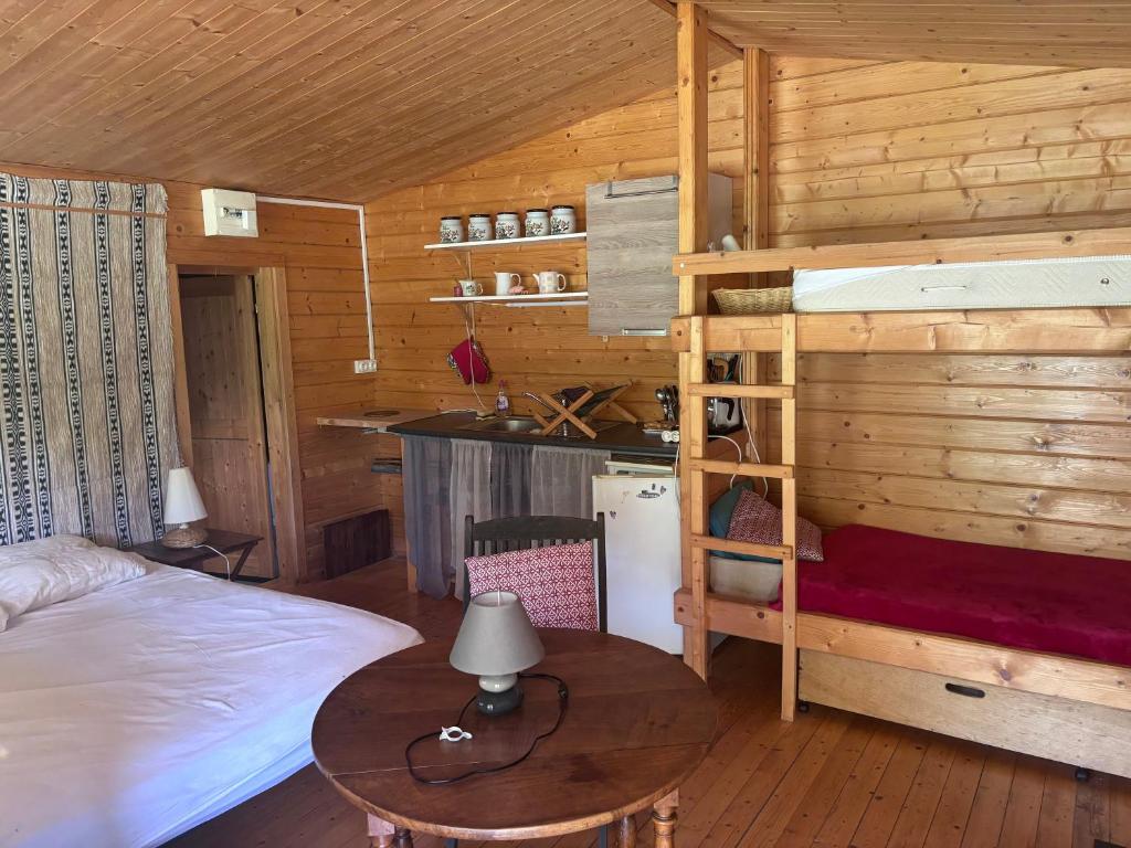 a bedroom with a bunk bed and a desk at Le chalet in LʼÉpine