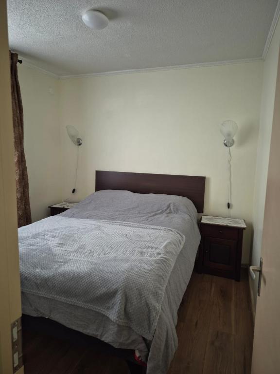 a bedroom with a bed and two lights on the wall at Aires in La Serena