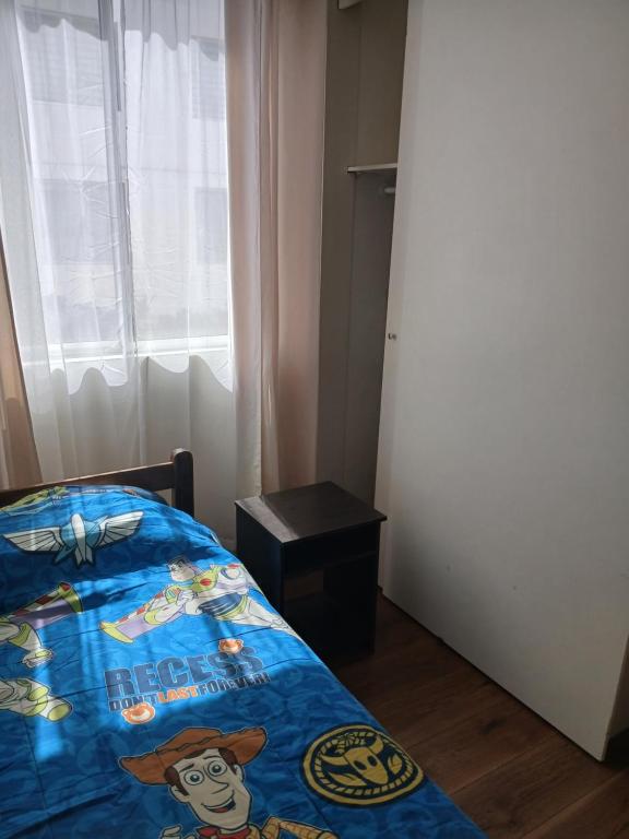 een slaapkamer met een bed met een Disney-deken erop bij Aires in La Serena