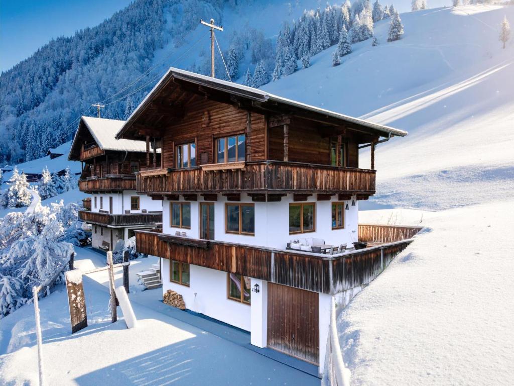 アルプバッハにあるTirola Chalet Alpbachの雪の中の雪に覆われた木造の家