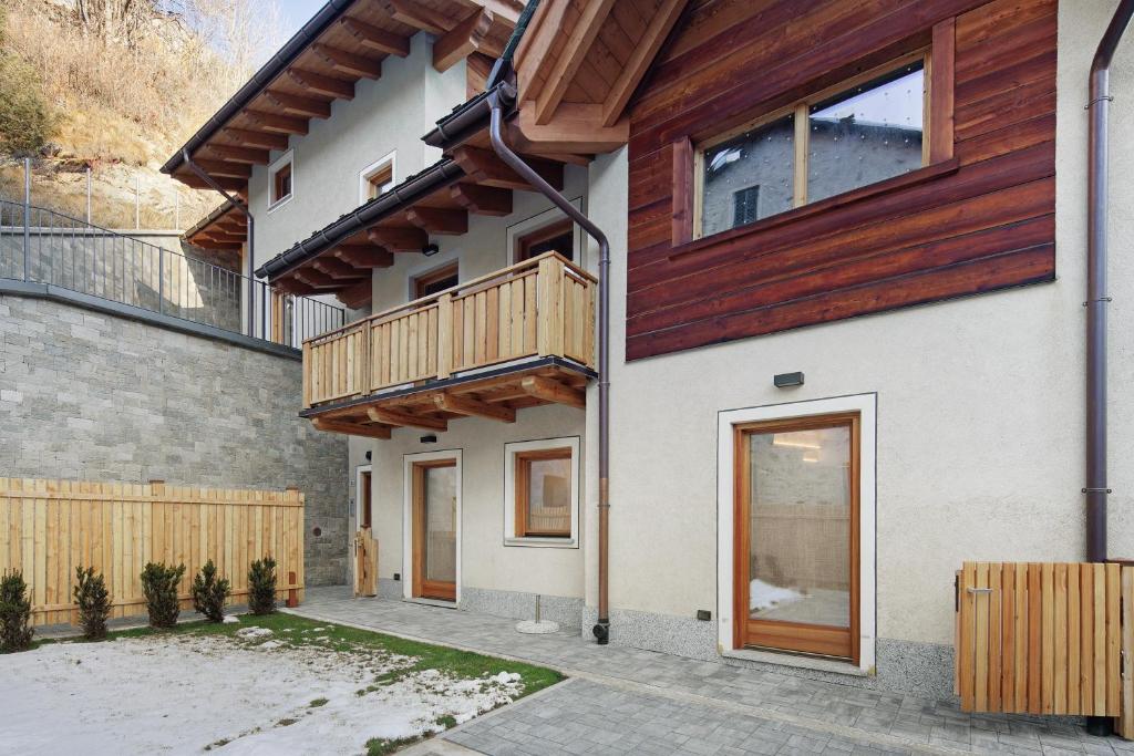 a house with wooden balconies on the side of it at Chalet Emma Isolaccia in Isolaccia