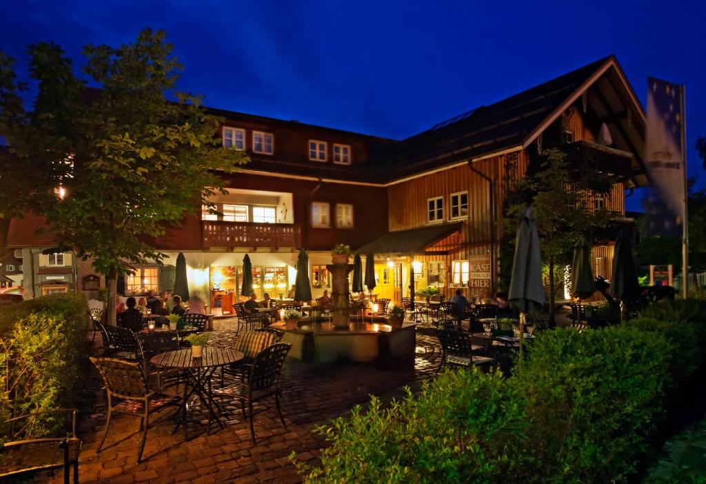 un restaurante al aire libre con mesas y sillas por la noche en Dorfhaus Chalets, en Oberstaufen