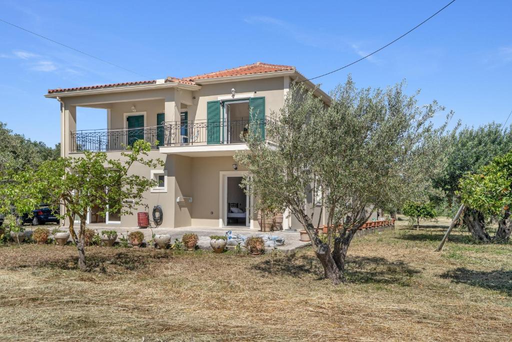a large house with trees in front of it at Panagis Apartments in Argostoli