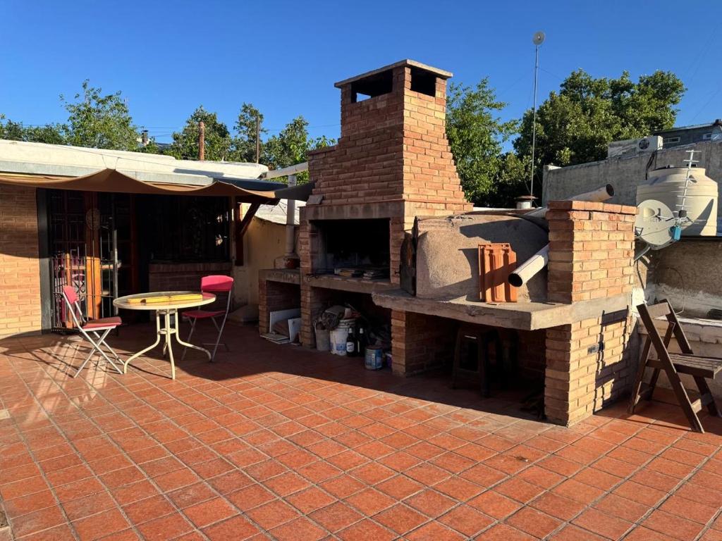 a brick patio with an outdoor oven with a table at Plaza Godoy Cruz, habitacion y baño privado en casa 6 ambientes terraza parrilla in Godoy Cruz
