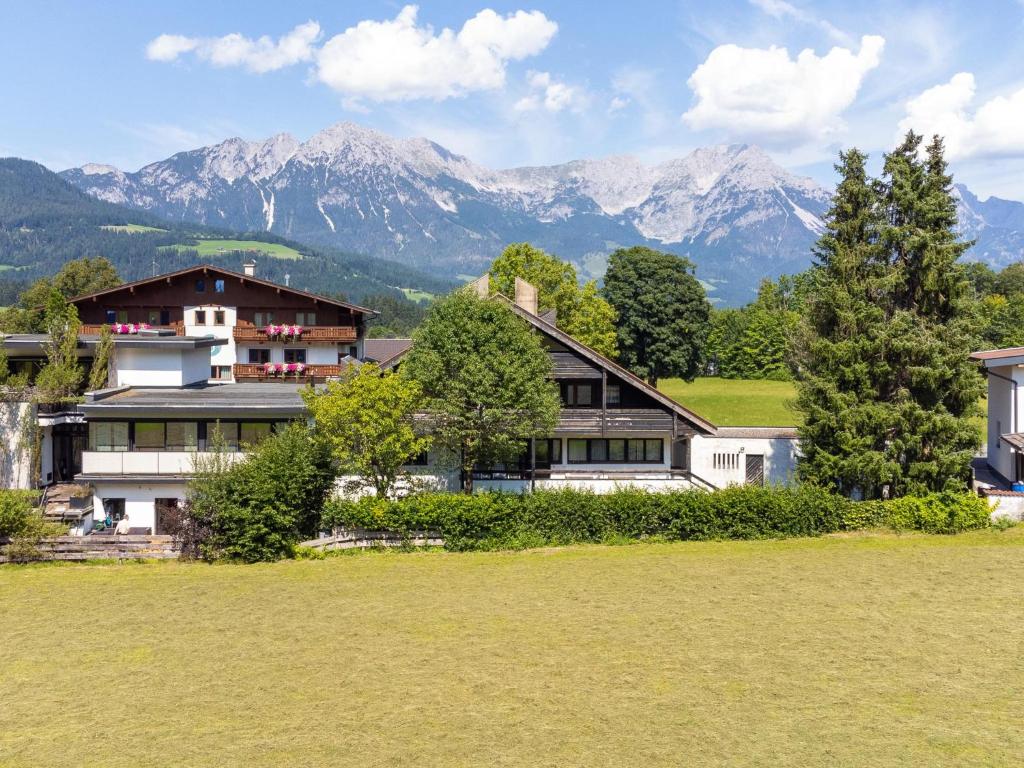 a house in a field with mountains in the background at An der Schiwiese in Söll