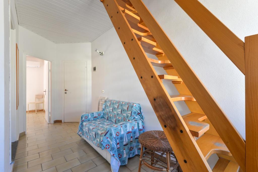 a living room with a staircase and a chair at Il Quadrifoglio 3 in Procchio