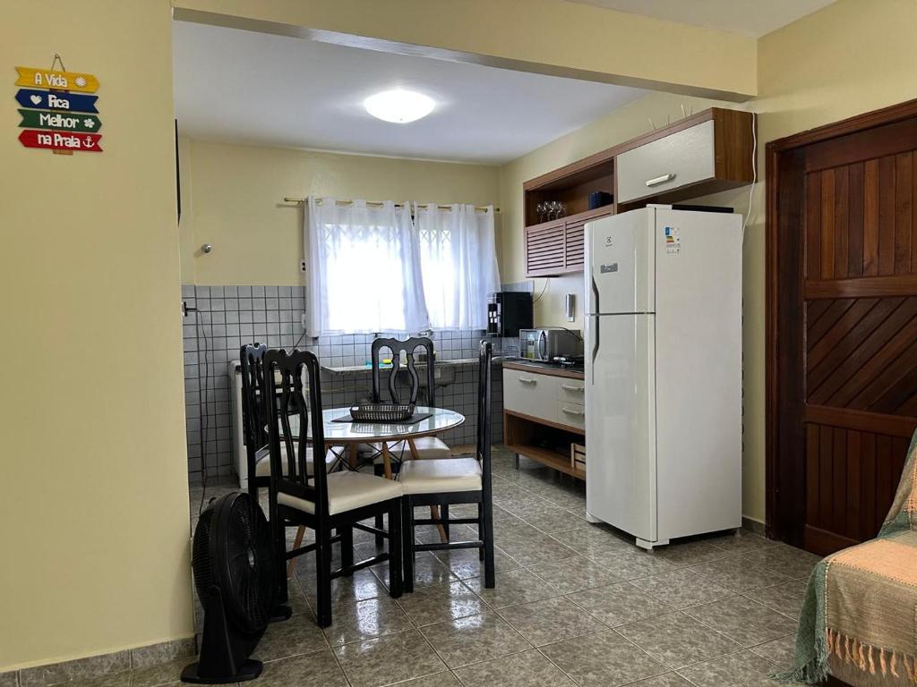 a kitchen with a table and a white refrigerator at Apto lindo em Alter do chão in Alter do Chao