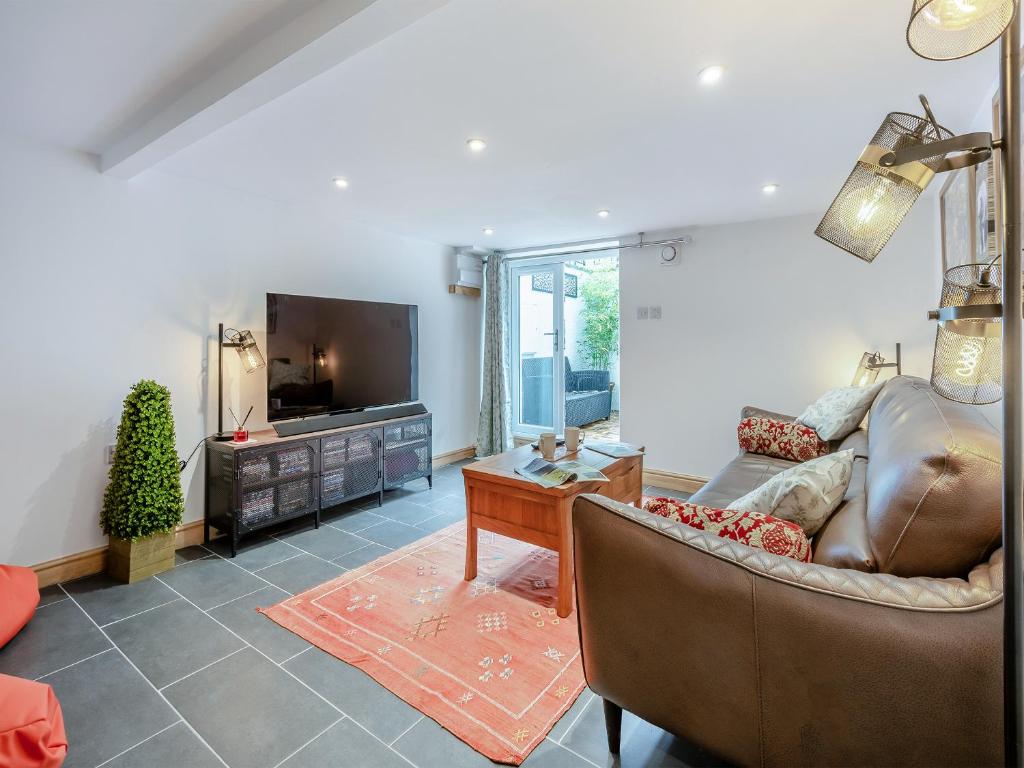 a living room with a couch and a tv at Stanley Cottage in Windermere