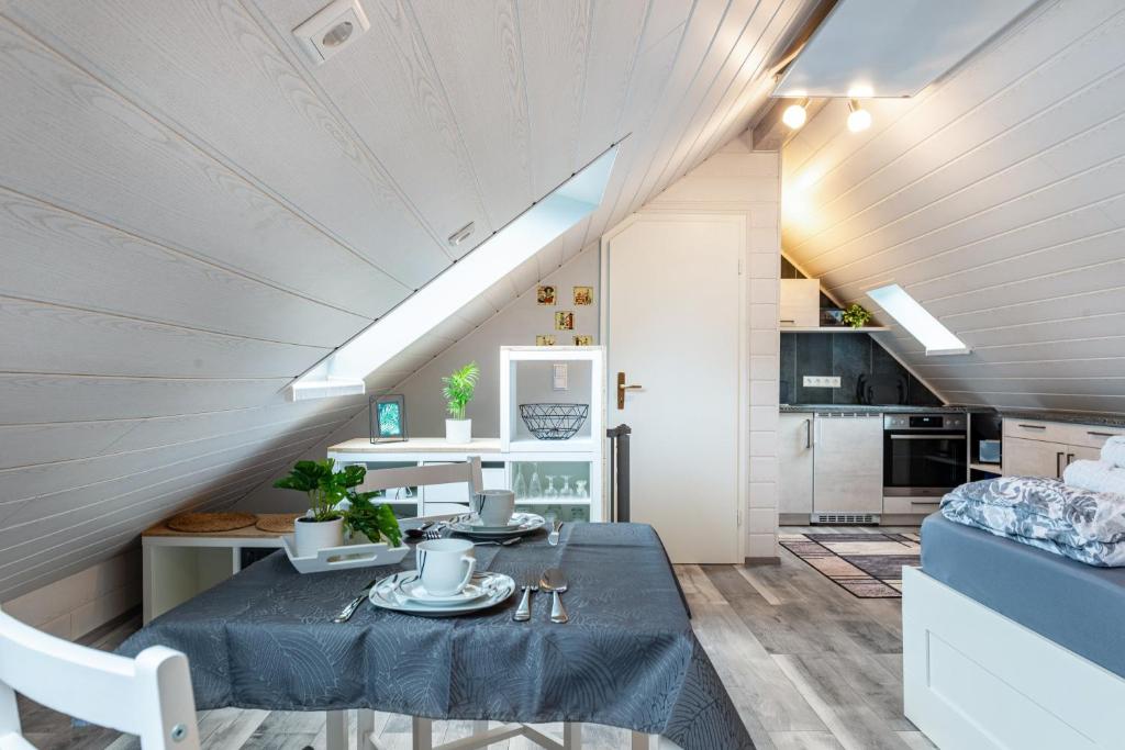 an attic kitchen and dining room with a table and a couch at Opitz in Allensbach