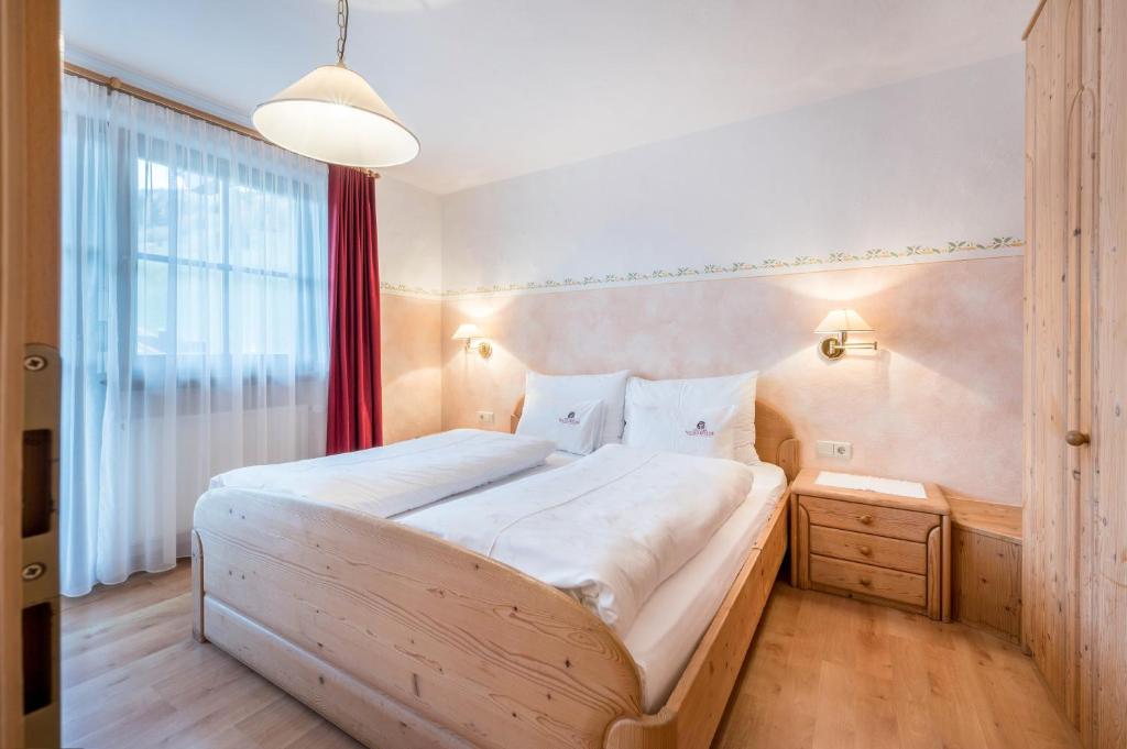 ドッビアーコにあるHaus zur Vogelweide App 3の大きなベッドと窓のある寝室