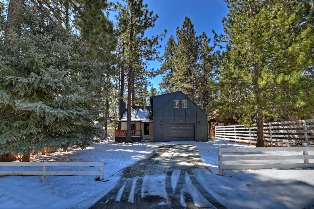 ビッグ・ベア・シティにある157 - Angelenos Cabin - Big Bear Getawayのフェンスの隣にある雪の中の黒い納屋