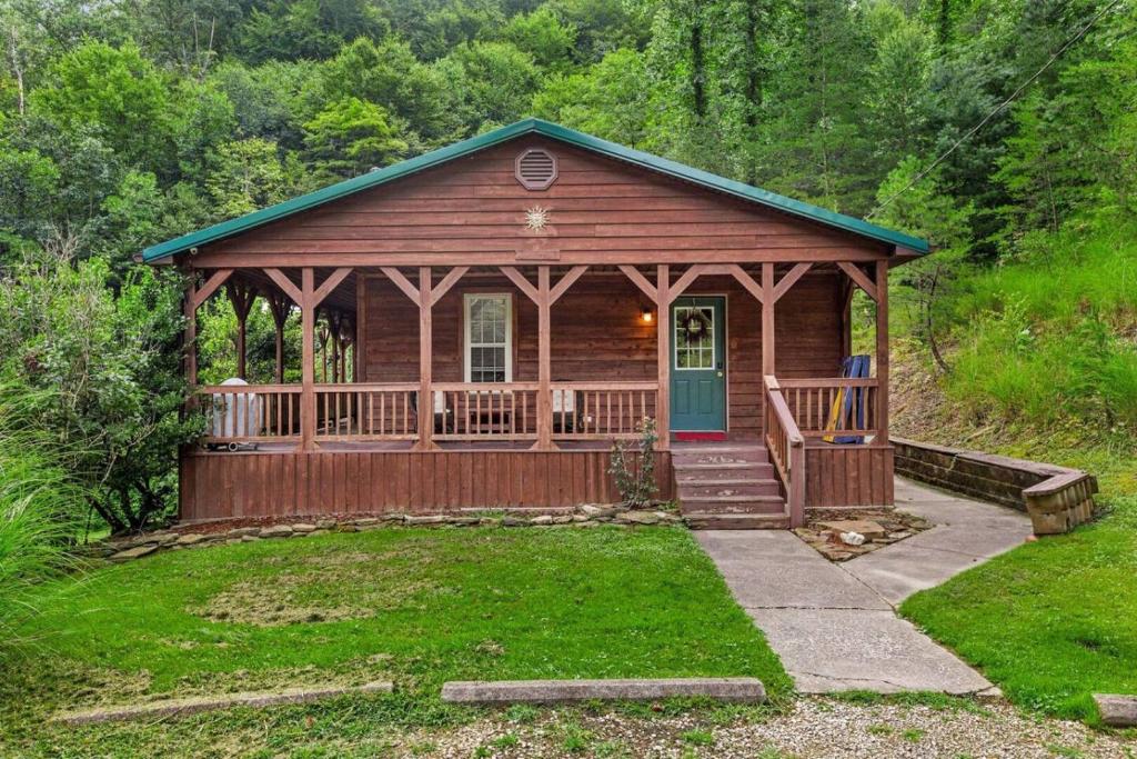 a wooden cabin with a porch and a green door at Sundance Cabin with Hot Tub and WiFi in Slade