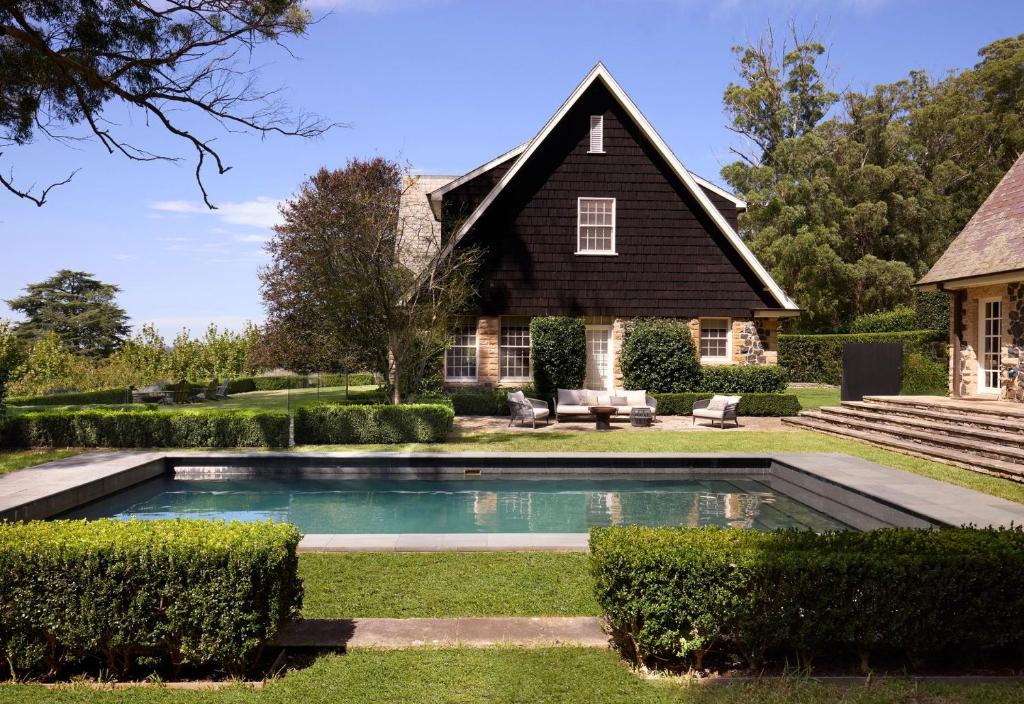 a home with a pool in front of a house at Hazelwood House in Mittagong