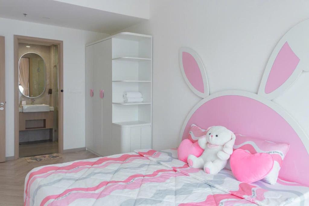Gò CôngにあるNice Homeのぬいぐるみのウサギとハートが飾られたピンクのベッドのある寝室