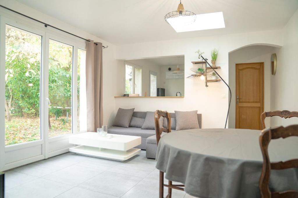 a living room with a table and a couch at Individual Guest House - Between Paris and Disneyland in Vaires-sur-Marne