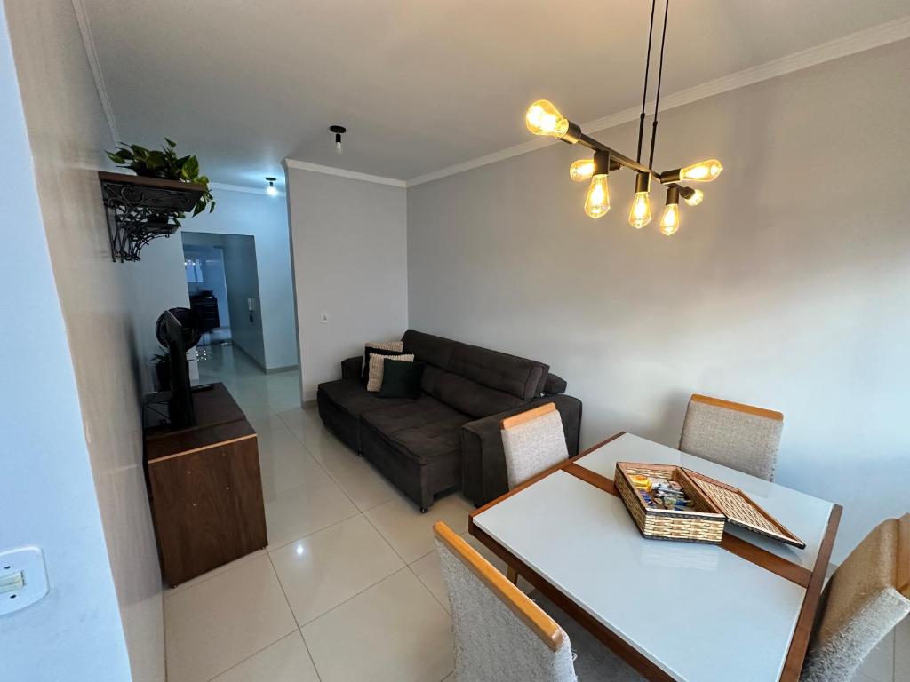 a living room with a table and a couch at Apto próx Hospital Regional até 6 pessoas com garagem e wifi in Nova Mutum