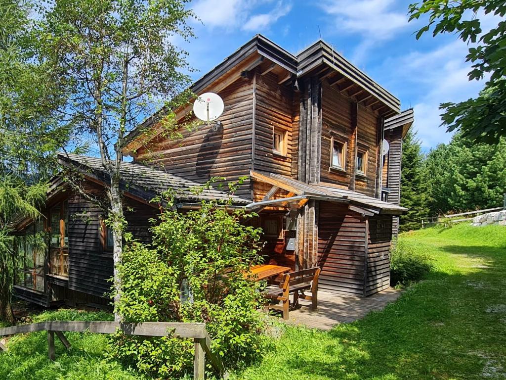 une maison en bois avec un banc devant elle dans l'établissement Marei Hütte, à Hohentauern