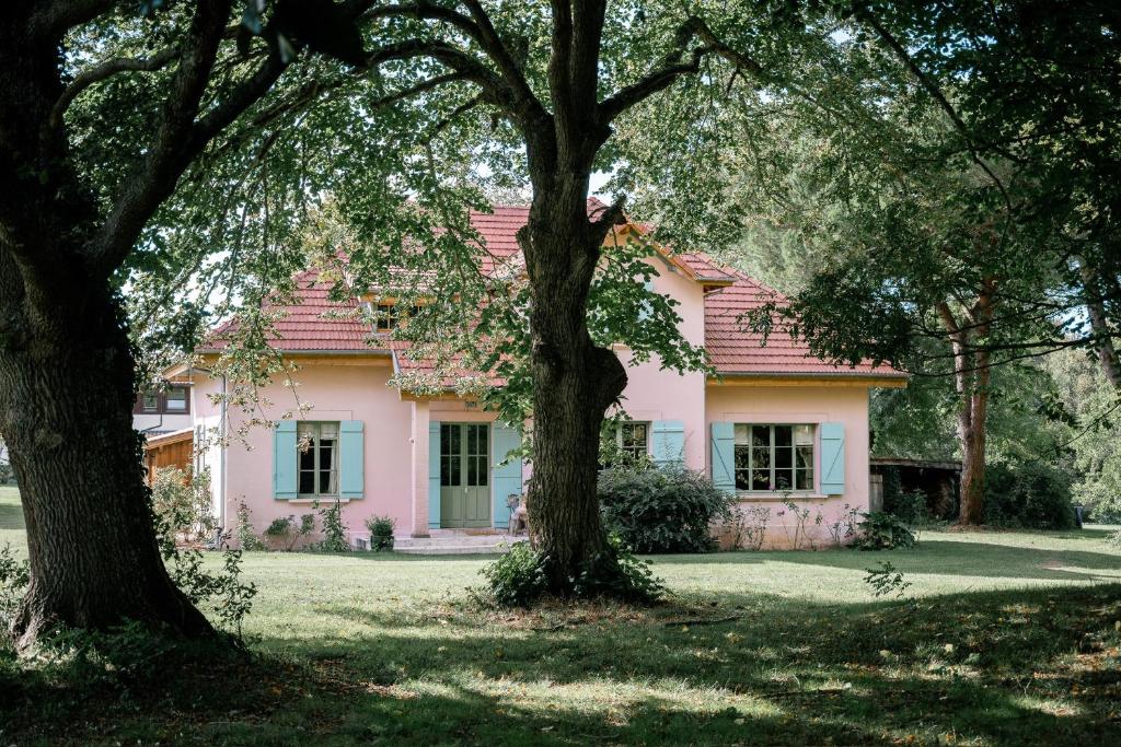 a pink house with trees in front of it at Villa La Maison Rose in Saint-Julien-en-Born