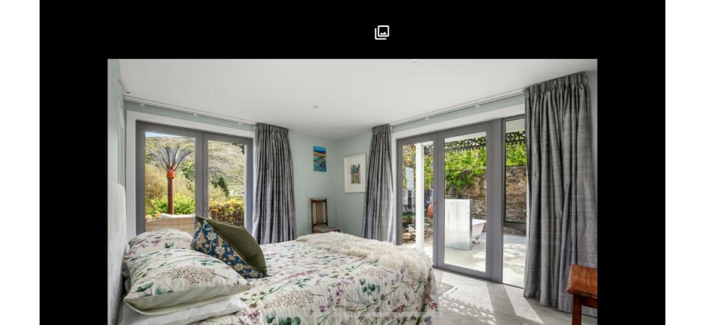 a bedroom with a bed and sliding glass doors at Miners Lane Guest House in Clyde