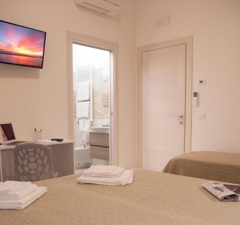 アルバ・アドリアティカにあるAlba D'Abruzzo Bed and Breakfastのベッド2台と窓が備わるホテルルームです。