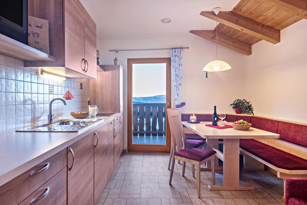 a kitchen with a table and a dining room at Schildberghof Ortler in Siusi