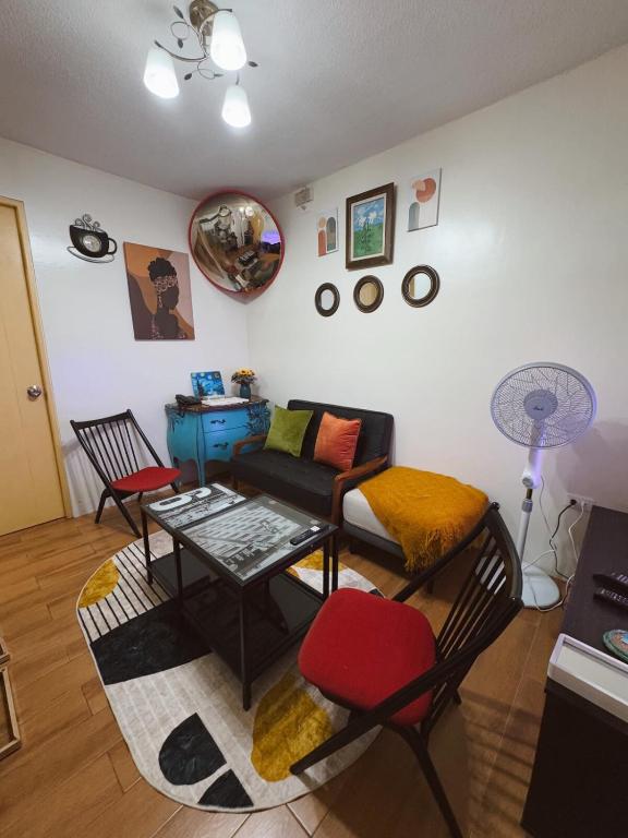 a living room with a couch and a table and chairs at 90's Themed 2 Bedroom Unit at Seawind Sasa, Davao City Philippines in Sampong
