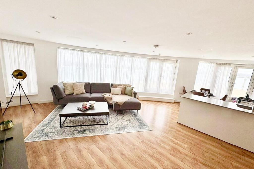 a living room with a couch and a table at Luxury 2-Bed 2-Bath Penthouse with Terrace in Harrow