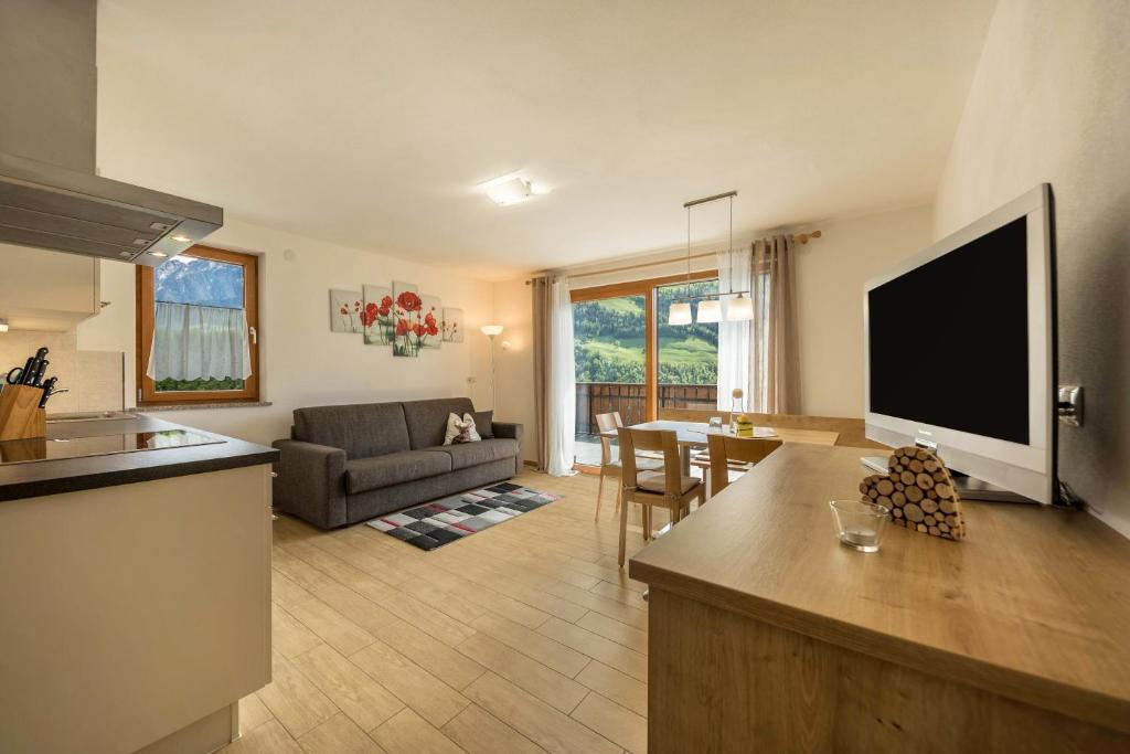 a kitchen and living room with a flat screen tv at Pfandlerhof Ferienwohnung Rot in San Martino