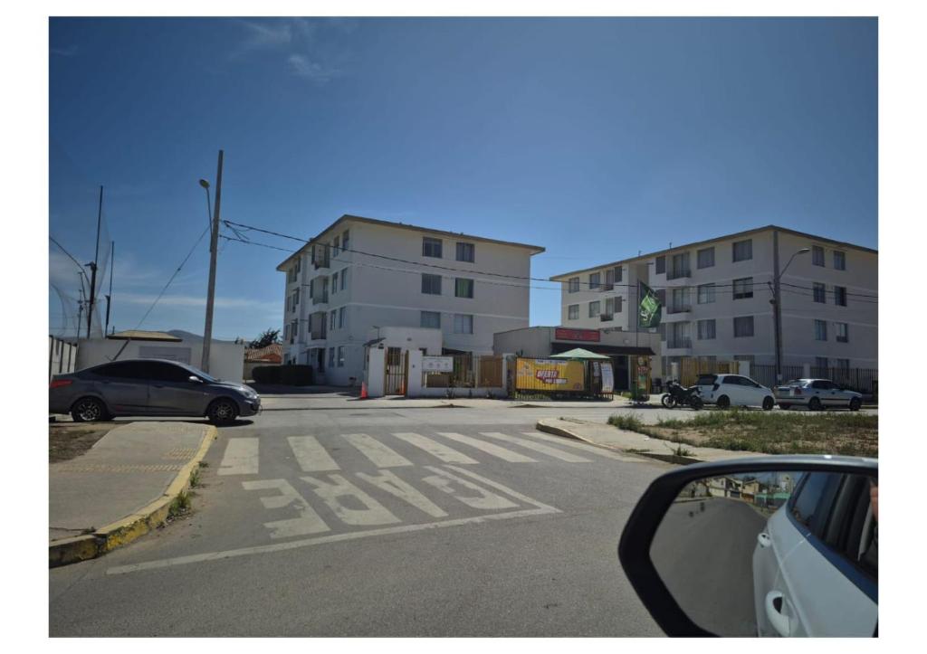 an empty street with cars parked on the side of a building at Aires in La Serena