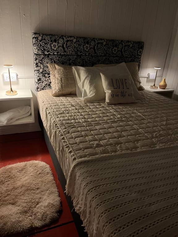 a bedroom with a large bed with love on it at Casa Prusia, tipica de pioneros europeos in Aristóbulo del Valle