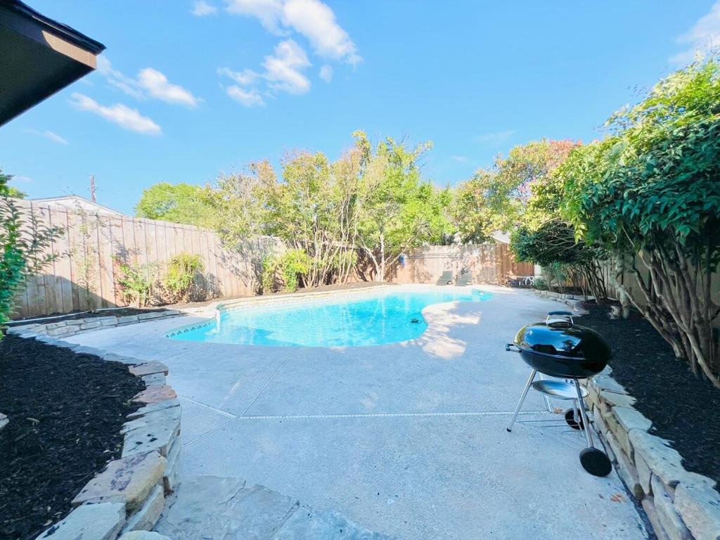 a swimming pool with a grill in a yard at Modern & Cozy house with pool in The Colony