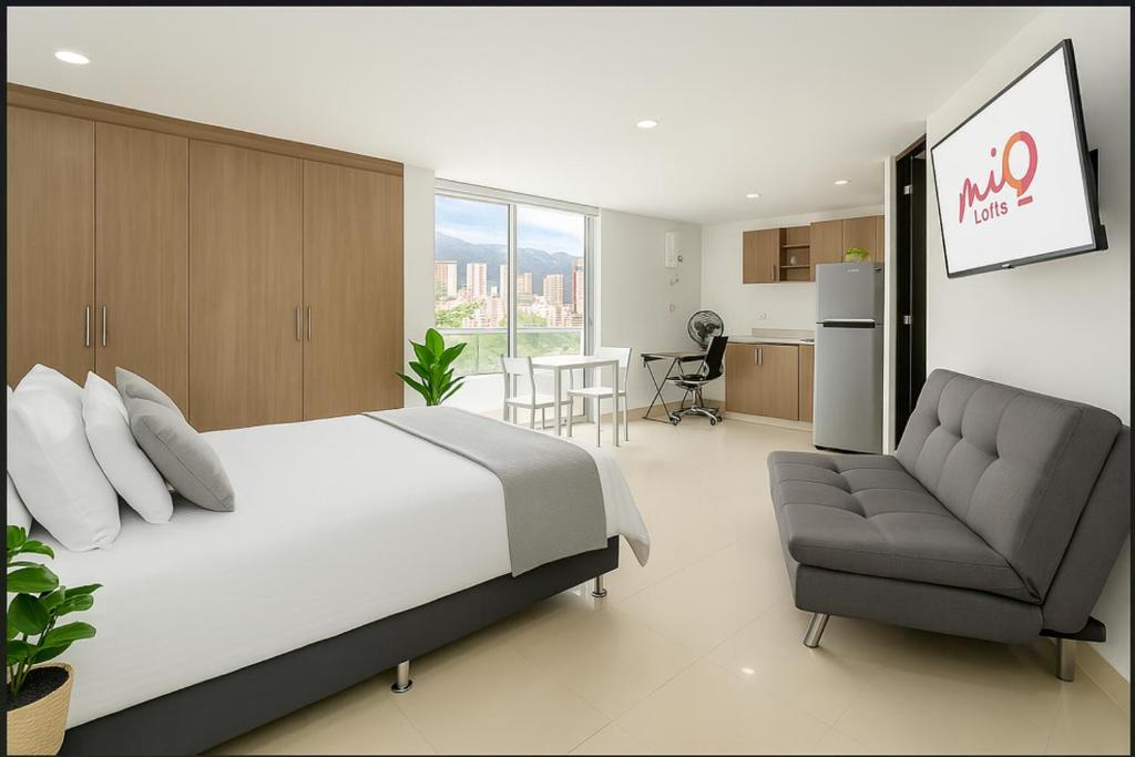 メデジンにあるEdificio La Frontera - Vista El Poblado Free Parking & Wifi Recep 24 hのベッドルーム1室(ベッド1台、ソファ付)、キッチン