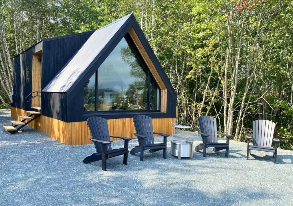 a tiny house with chairs and a table at Bay View A-Frame, Firepit, Bath Tub, Near Acadia in Gouldsboro