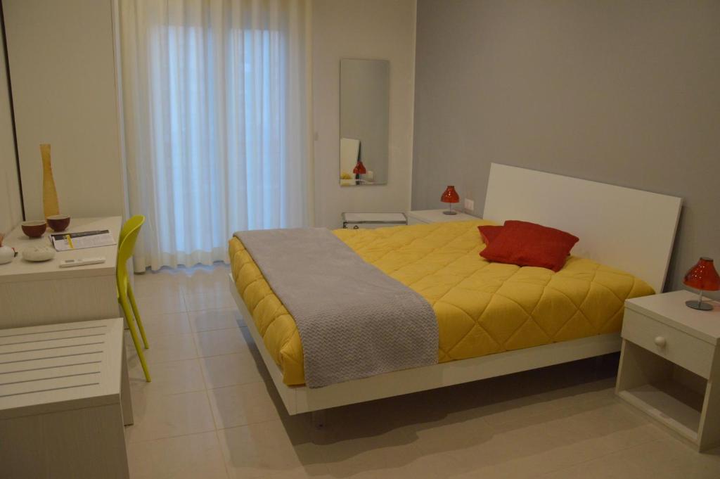 una camera con letto giallo e cuscino rosso di Matera Sassi Rooms 21/a e 21/b a Matera