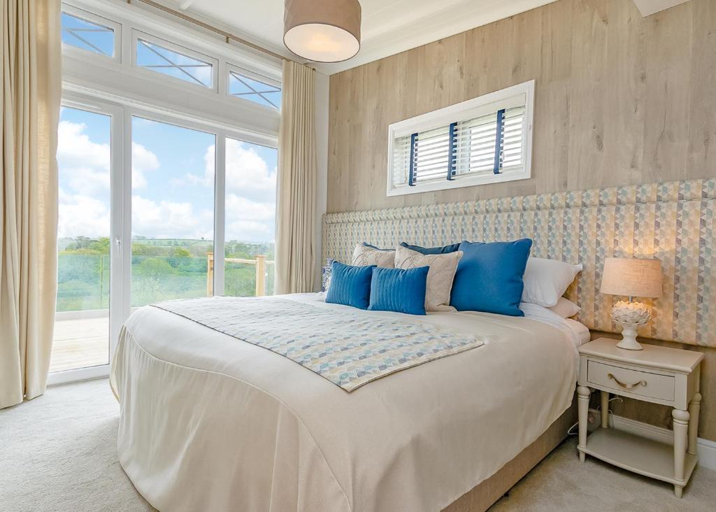 a bedroom with a large white bed with blue pillows at Celtic Escapes in Narberth