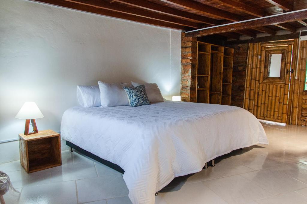 a bedroom with a large white bed in a room at Hotel Internacional de Arte PIA in Marinilla