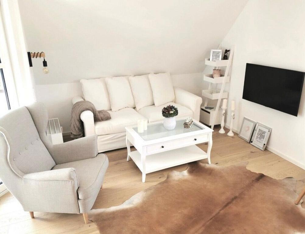 a living room with a white couch and a tv at Apartment Blackforest-Schluchsee in Schluchsee