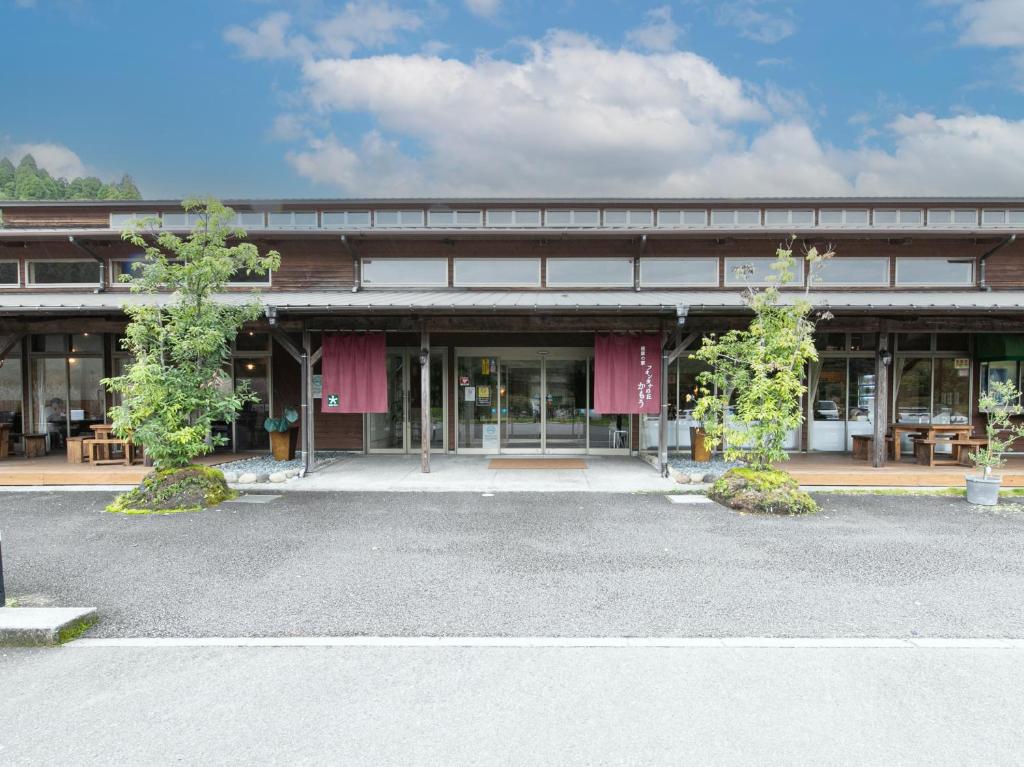 a building with a parking lot in front of it at Tabist Fontana no Oka Kamou in Aira