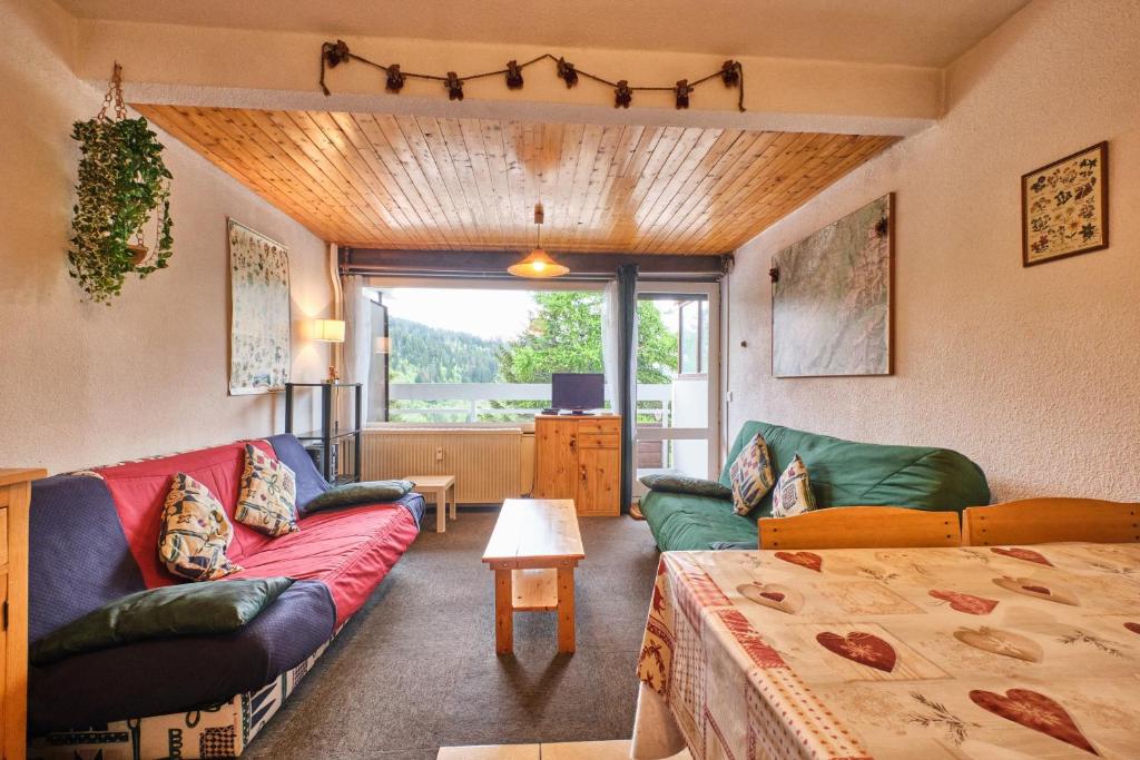 a living room with a couch and a table at Eterlou 101 in Chamrousse